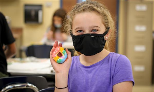 Girl holds up food model made of clay